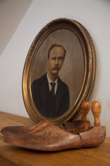 Angled profile of the vintage painted portrait, showing the distressed finish on the gold oval frame.