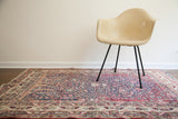 Antique Persian Kerman rug with a unidirectional prayer design in mellow shades of red, navy, and cream.