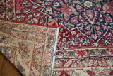 Folded corner of an antique Persian Kerman rug revealing its hand-knotted woven foundation.