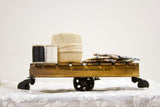 A classic tabletop mini cart with a torched pine wood body and black industrial wheels.