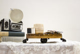A large tabletop mini cart styled decoratively with vintage spools of thread and cameras.