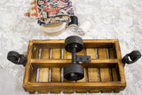 Black porcelain swivel casters on the torched wood base of a mini industrial cart.
