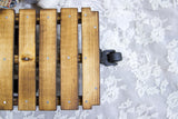 Overhead detail of the mini cart's torched pine slats and black antique-style wheel.