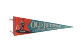 Old Bethpage Village Restoration felt pennant in red and blue with a vintage farmer illustration.