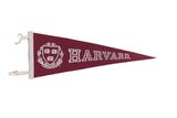 Maroon felt Harvard pennant with white lettering, crest, and trim, 9 by 24 inches.