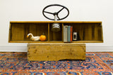 Vintage 1940s wooden boat helm's slatted shelves holding a duck, books, and camera.