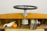 Vintage wooden boat helm with internal shelving displaying books, swan, and gourd.