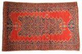 4x6 antique tomato red Malayer rug with an elongated dark blue geometric medallion