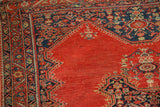 Antique Tomato Red Malayer rug corner detail with dark blue geometric border.