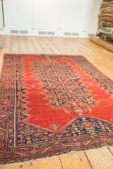 4x6 Antique Tomato Red Malayer Rug shown at an angle highlighting the intricate blue pattern.