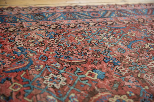 Angled close-up of faded red and blue herati pattern on antique Bakshaish rug.