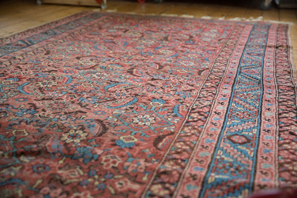 Angled view of an antique Bakshaish rug's faded Herati pattern and blue border detail, measuring 5' x 13'.