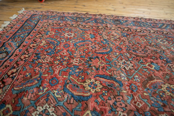 Angled view of the allover herati motif and low wool pile on an antique Bakshaish rug.