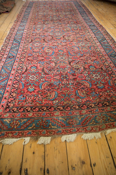 Low-angle perspective down the length of an antique Persian Bakshaish rug with a red herati motif.