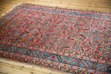 Angled view of a 5x13 antique Bakshaish rug showing the faded herati pattern and Caucasian-style floral borders.