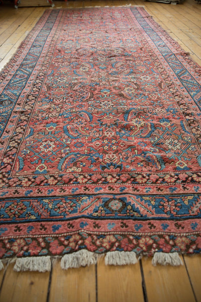 Angled perspective of a vintage Bakshaish rug highlighting the low pile, detailed borders, and end fringe.