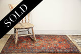 Shabby Lilihan rug, muted cranberry red field with blue and cream floral patterns.