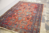 Worn pile and muted cranberry red floral pattern of the shabby Lilihan rug.
