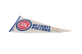 Angled view of a vintage Detroit Pistons pennant showing its time-softened off-white felt.