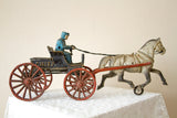 Cast iron Chief horse and buggy toy with blue driver and red wheels.