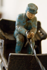 Close-up of the cast iron driver figure, showing a chipped blue uniform and cap.