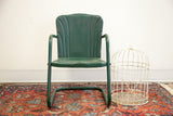 Deep green vintage metal kids tulip chair showing curved back and weathered finish.