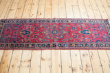 Vintage Sarouk runner's rich cranberry field, navy border, and unusual blue motifs.