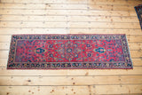 Vintage Sarouk runner showing saturated cranberry red field with unusual blue medallion and floral border.