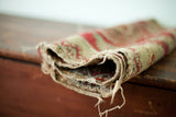 Character-rich tattered selvage and woven pile of a tribal motif antique rug.