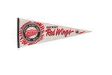 Vintage Detroit Red Wings felt pennant, cream, red, and black, showing age-softened patina, 12x29 inches.