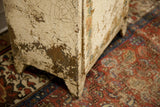 Heavily crazed and chippy paint finish on the corner of the vintage metal cabinet.