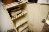 The aged and worn interior shelves of the chippy vintage industrial metal cabinet.