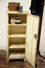 The aged interior and worn shelves of the vintage chippy metal cabinet.