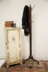 Chippy industrial metal cabinet styled in a vintage setting with a coat rack and Persian rug.