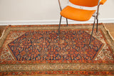 Tattered right edge of the vintage tribal rug in indigo blue and red patterns.
