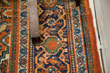 Vintage Persian Hamadan rug's intricate tribal Herati pattern in burnt orange, navy, and green.