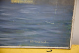 Signature of artist Gil Edwards in gold lettering on the textured blue painting.