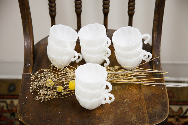 The set of twelve milk glass punch cups arranged in four stacks.