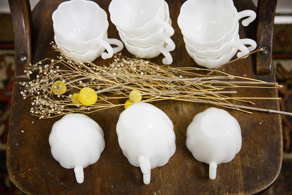 Overhead view of milk glass punch cups showcasing their scalloped rims and swirl pattern.