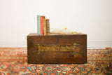 Antique wooden trunk with hand-painted 'Rascal IV' label and a warm, aged patina.