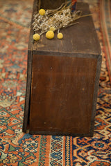 Detail of handmade antique Rascal trunk's dark wood side with aged texture and scratches.