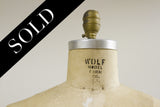 Wolf Dress Form neck with visible brand stamp, aged linen texture, and brass finial.