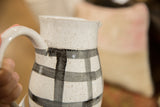 Speckled ceramic texture and hand-painted black and white gingham pattern on pitcher.