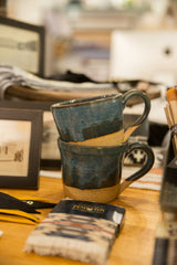 Textured dark midnight blue ceramic mug, showcasing its hand-glazed finish and raw clay base.