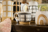 Handmade ceramic black and white gingham mug with speckled rim and natural base.