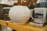 Handmade round ceramic vase with soft blush stripes on a glossy ivory glaze.