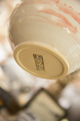 Bracken Fern Studio maker's stamp on the unglazed base of the ivory ceramic vase.