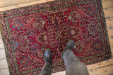Antique German Sarouk rug seen from above, showing its scale and intricate cherry red pattern.