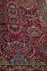 Intricate floral sprays showing the hand-knotted texture of an antique German Sarouk's red field.