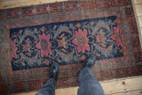 Visible foundation and worn pile on navy blue Hamadan rug with raspberry florals.